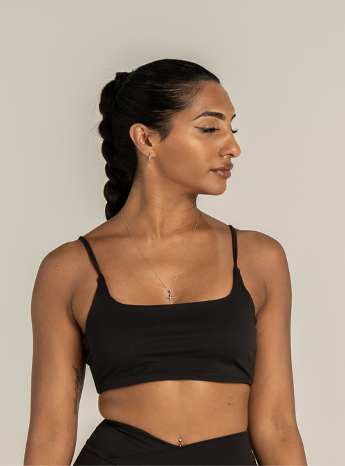 Boxy Bralette in Carbon, a black bralette with thin straps, front view on a model