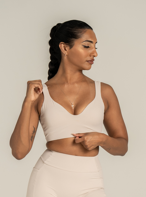 Club Crop in Sicilian Sand, a sand coloured sports bra, front view on a model