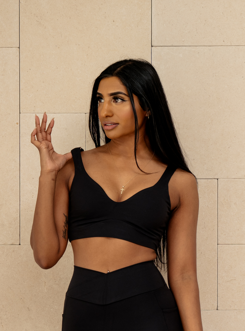 Club Crop in Carbon, a black sports bra with a sweetheart neckline, front view on a model