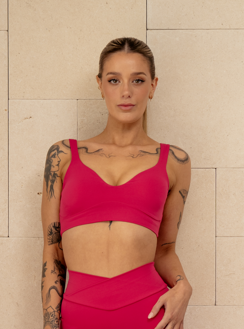 Club Crop in Plastic Pink, a pink sports bra with a sweetheart neckline, front view on a model